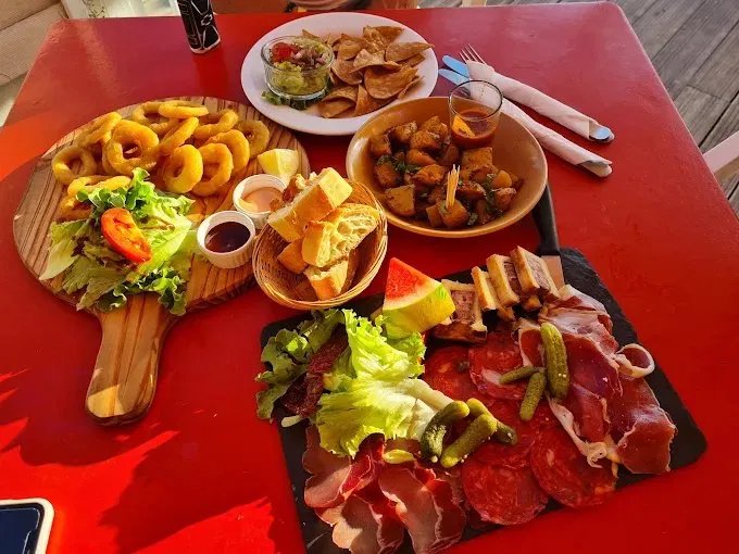 Planche de charcuterie et tapas sur table rouge