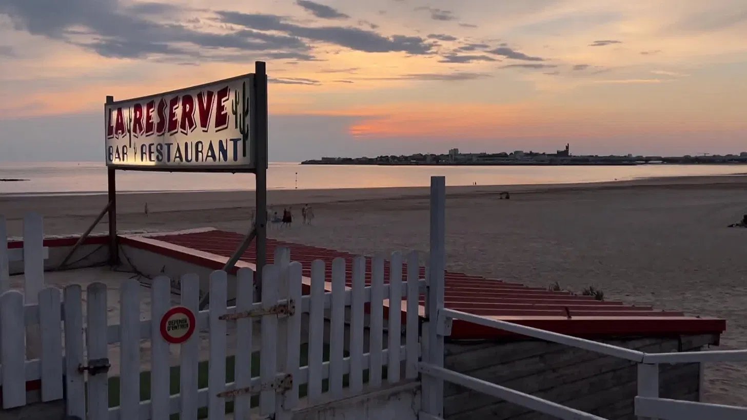 L'enseigne La Réserve face à l'océan au coucher du soleil