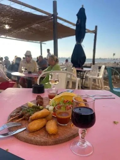 Verre de vin et planche de tapas au coucher du soleil